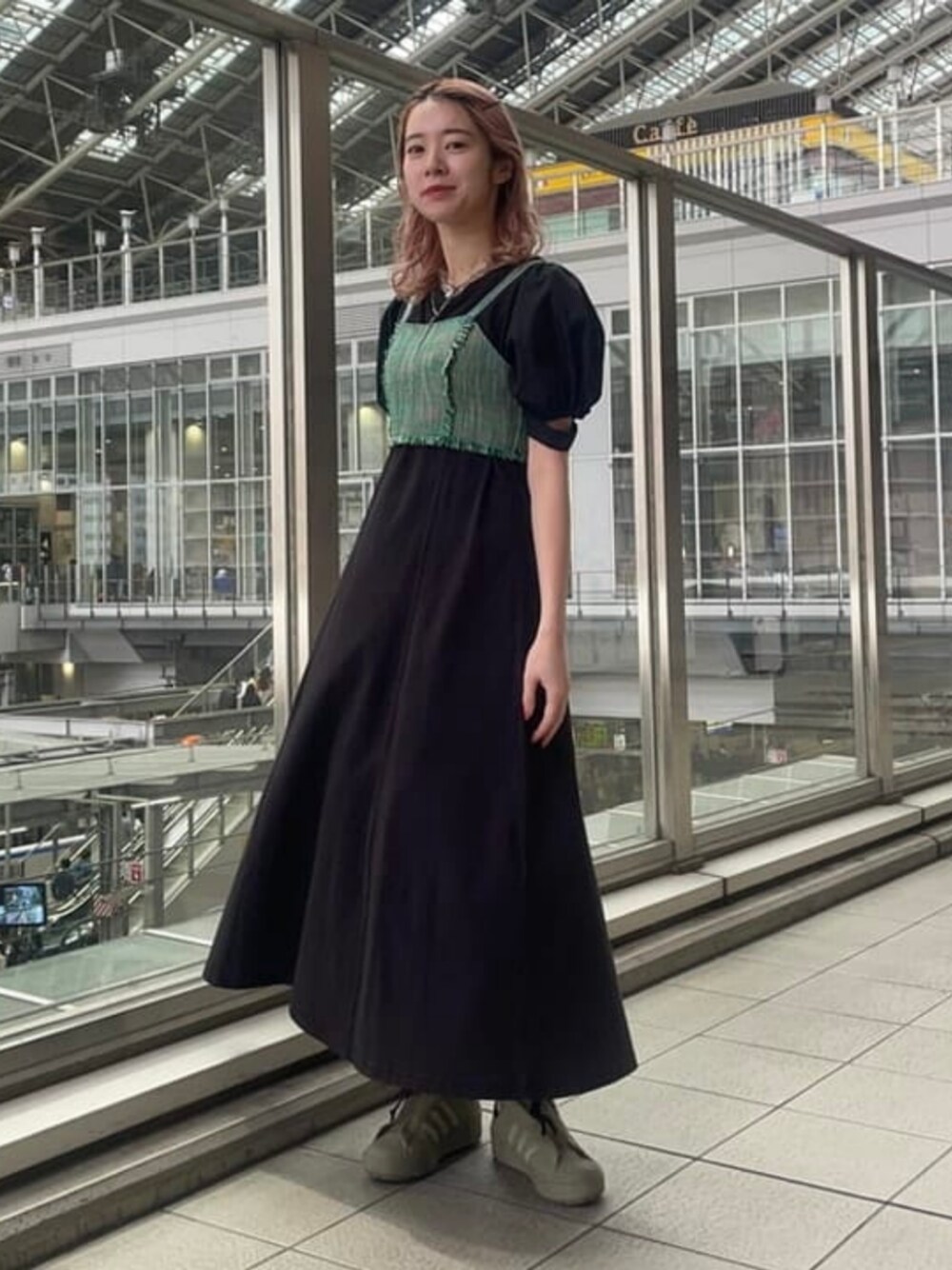 グリーン系のキャミソール、ブラック系のワンピースを着用したレディースの春コーディネートの1枚目の写真