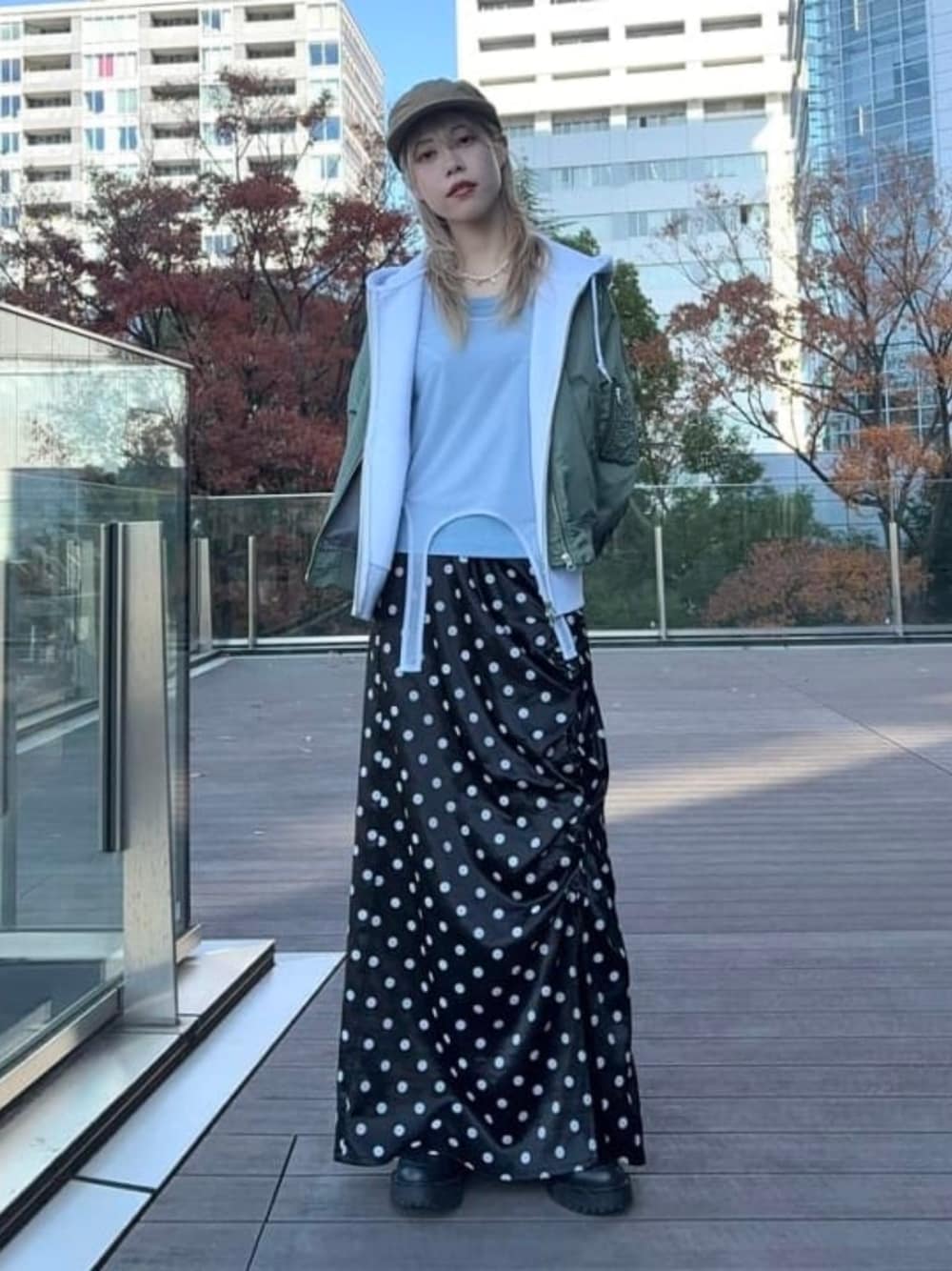 ブラック系のスカート、グリーン系のMA-1、ブラウン系のキャップを着用したレディースの冬コーディネートの1枚目の写真