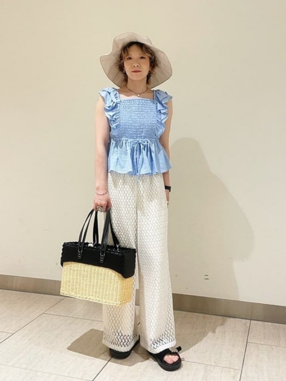 ブルー系のシャツ/ブラウス、ホワイト系のその他パンツ、ブラック系のトートバッグを着用したレディースの夏コーディネートの1枚目の写真