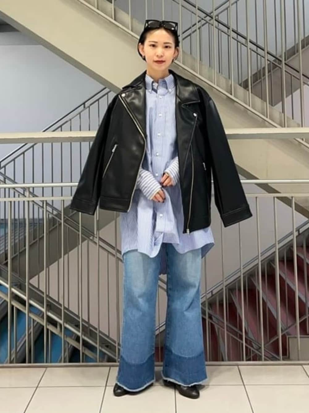 ブラック系のライダースジャケットを着用したレディースの冬コーディネートの1枚目の写真