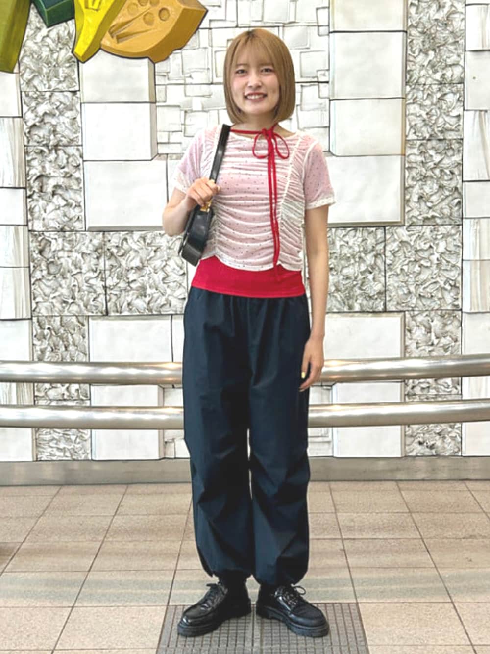 ブラック系のハンドバッグ、レッド系のTシャツ/カットソーを着用したレディースの夏コーディネートの1枚目の写真