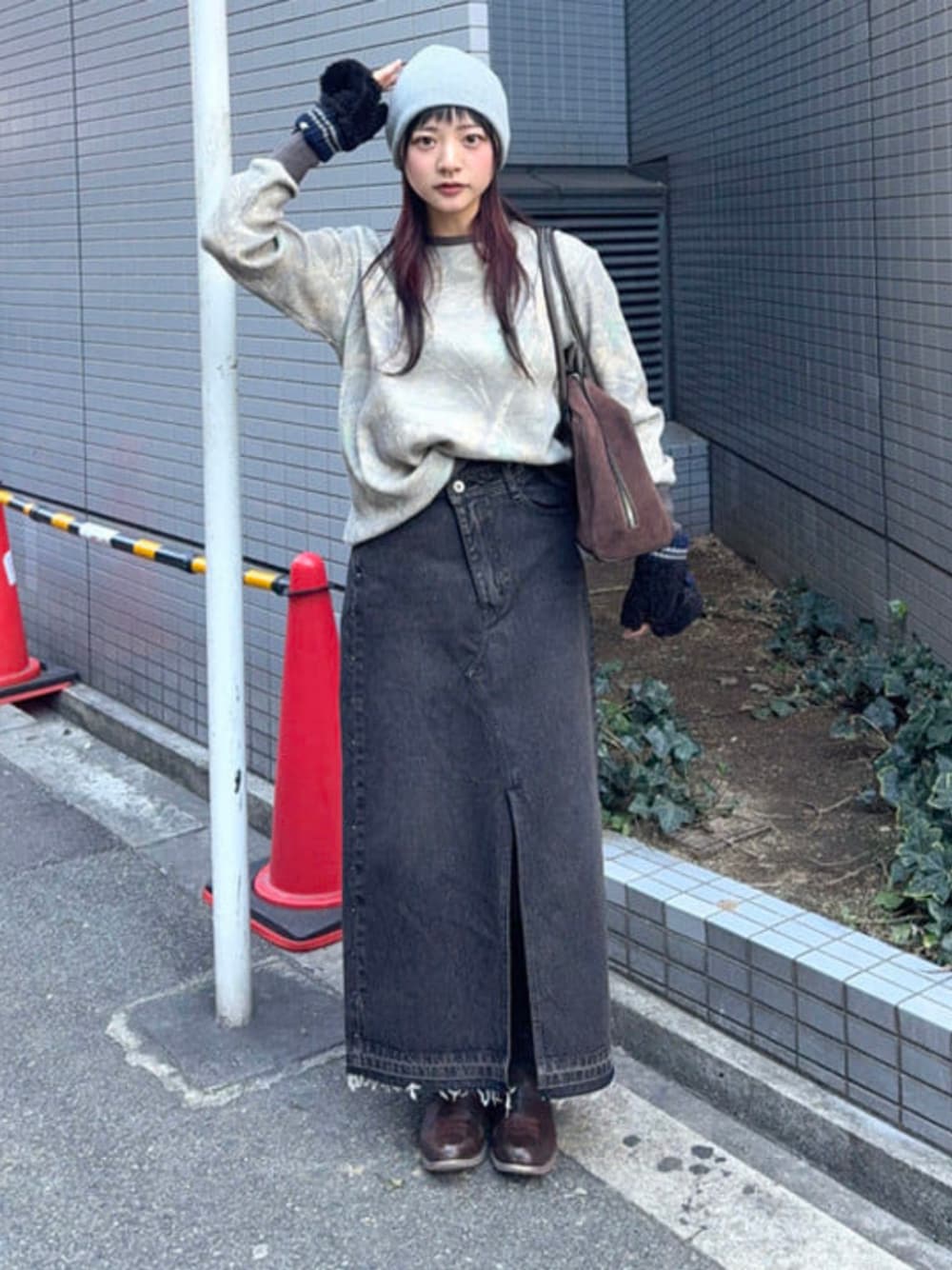 ブラック系のスカート、ブラウン系のボストンバッグ、ベージュ系のTシャツ/カットソーを着用したレディースの冬コーディネートの1枚目の写真