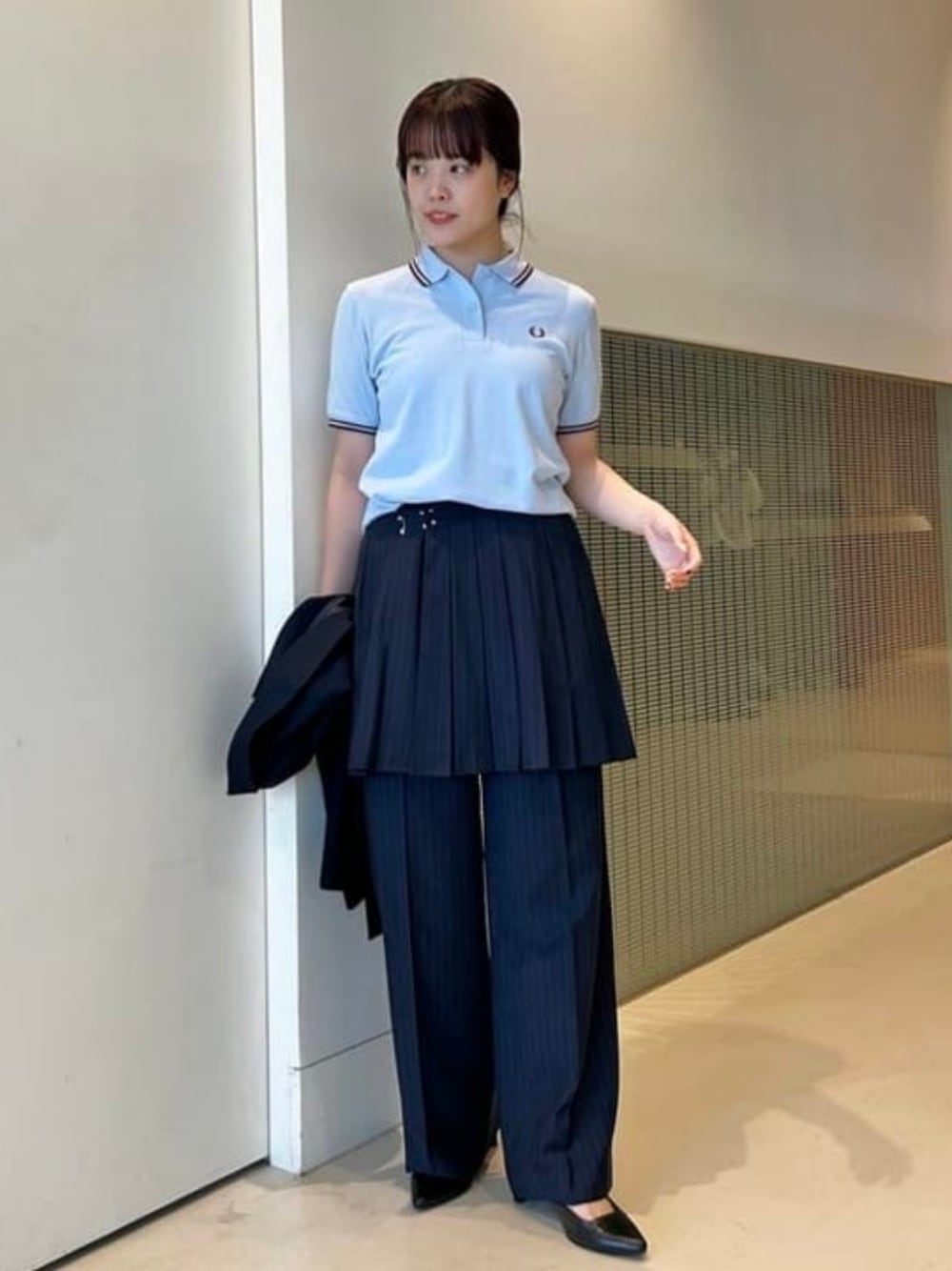 ブラック系のサンダル、ブルー系のスカート、ブルー系のポロシャツを着用したレディースの冬コーディネートの1枚目の写真