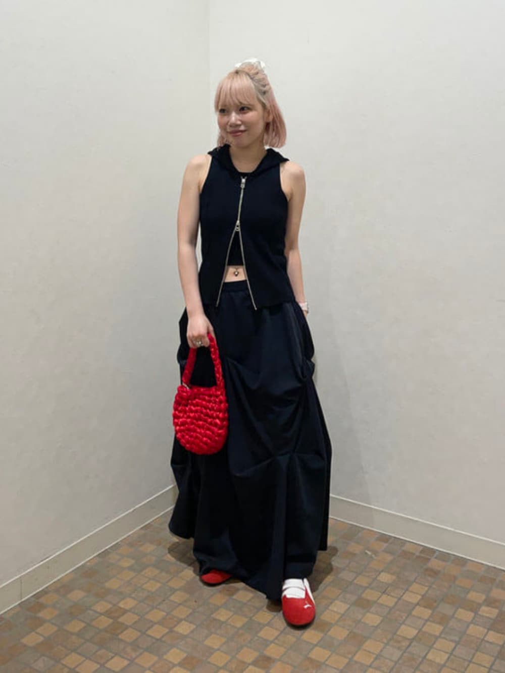 ブラック系のベスト、レッド系のスニーカー、レッド系のトートバッグを着用したレディースの夏コーディネートの1枚目の写真