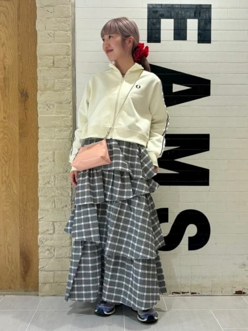 ホワイト系のジャージ、ブラック系のスカートを着用したレディースの春コーディネートの1枚目の写真