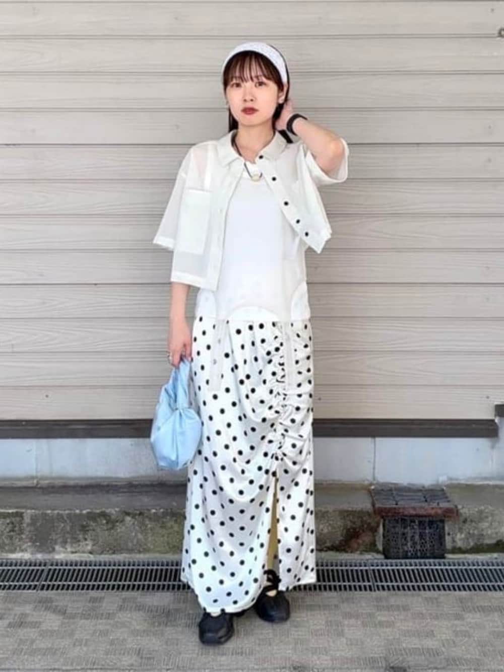 ブルー系のトートバッグ、ホワイト系のスカート、ホワイト系のタンクトップを着用したレディースの夏コーディネートの1枚目の写真