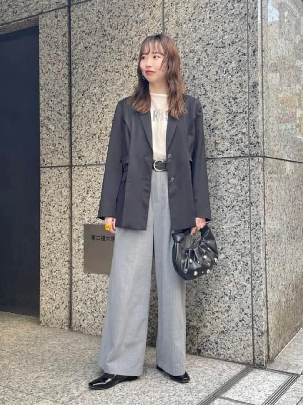 ブラック系のドレスシューズ、ブラック系のテーラードジャケット、ブラック系のハンドバッグを着用したレディースの春コーディネートの1枚目の写真