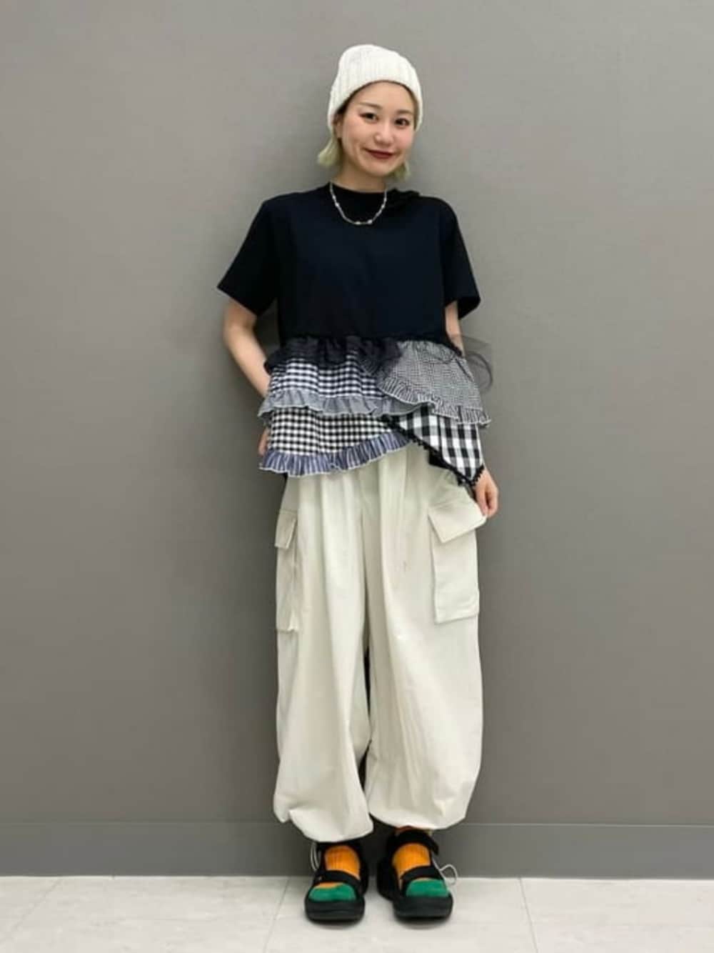 ブラック系のサンダル、ホワイト系のカーゴパンツ、ブラック系のTシャツ/カットソーを着用したレディースの春コーディネートの1枚目の写真