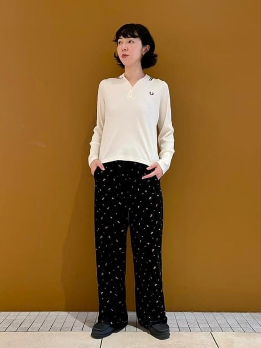 ブラック系のその他パンツ、ホワイト系のポロシャツを着用したレディースの秋コーディネートの1枚目の写真