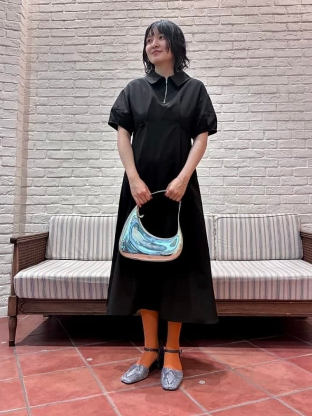 シルバー系のトートバッグ、ブラック系のワンピース、その他のパンプスを着用したレディースの春コーディネートの1枚目の写真