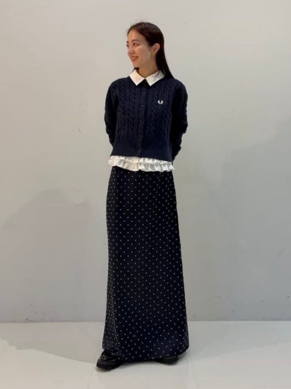 ブルー系のカーディガン/ボレロ、ホワイト系のシャツ/ブラウス、ブルー系のスカートを着用したレディースの秋コーディネートの1枚目の写真