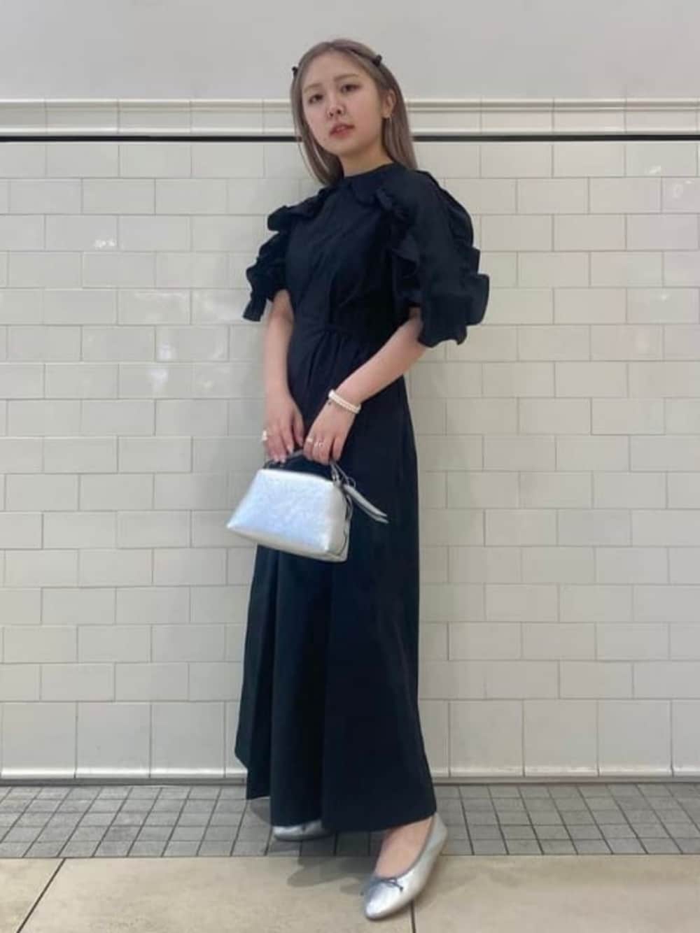 ブラック系のワンピース、シルバー系のバレエシューズ、シルバー系のショルダーバッグを着用したレディースの春コーディネートの1枚目の写真