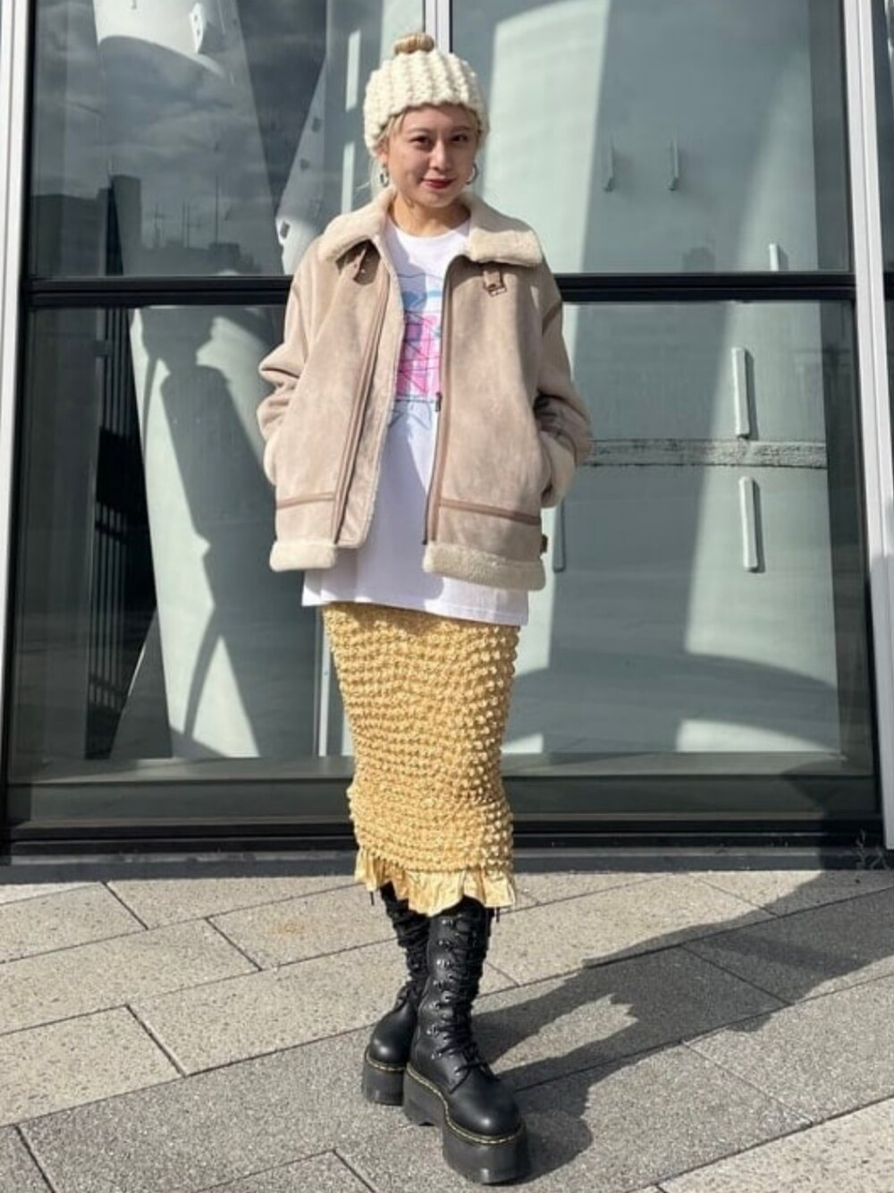 ベージュ系のムートンコート、ホワイト系のTシャツ/カットソー、ホワイト系のハットを着用したレディースの冬コーディネートの1枚目の写真