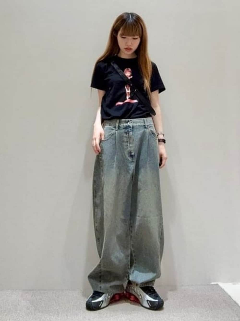シルバー系のスニーカー、ブラック系のTシャツ/カットソー、ブルー系のデニムパンツを着用したレディースの夏コーディネートの1枚目の写真