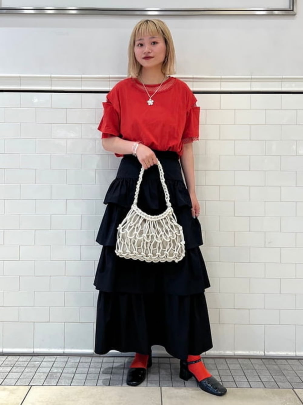 ブラック系のパンプス、ブラック系のスカート、ホワイト系のトートバッグを着用したレディースの夏コーディネートの1枚目の写真