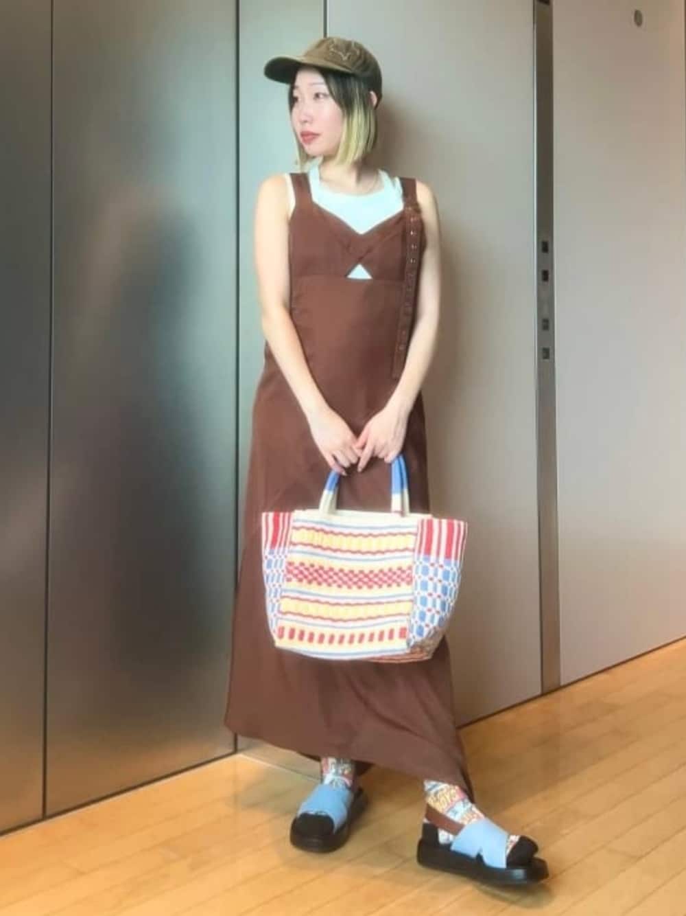 グリーン系のタンクトップ、ブラウン系のワンピース、ブルー系のかごバッグを着用したレディースの夏コーディネートの1枚目の写真