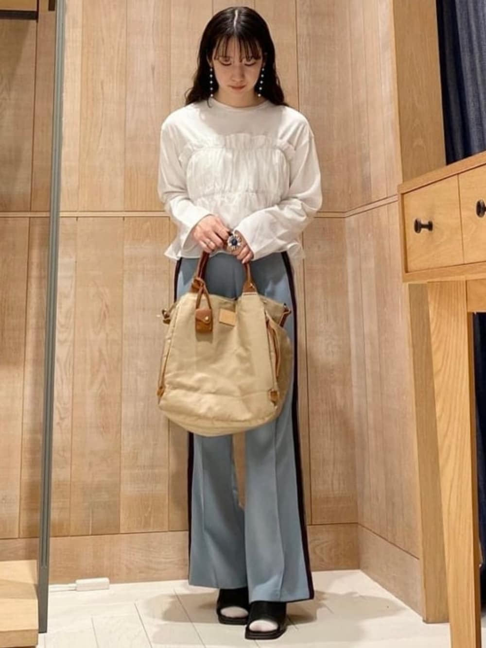 ベージュ系のトートバッグ、ブルー系のその他パンツ、ホワイト系のTシャツ/カットソーを着用したレディースの春コーディネートの1枚目の写真
