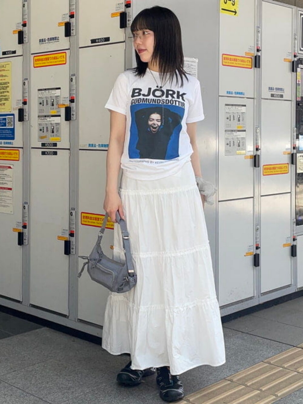 グレー系のトートバッグ、ホワイト系のTシャツ/カットソーを着用したレディースの夏コーディネートの1枚目の写真