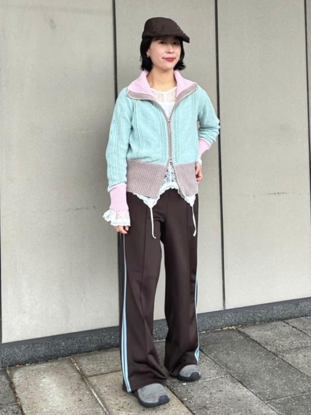 グリーン系のニット/セーター、ブラウン系のその他パンツ、ブラウン系のハンチング/ベレー帽を着用したレディースの秋コーディネートの1枚目の写真
