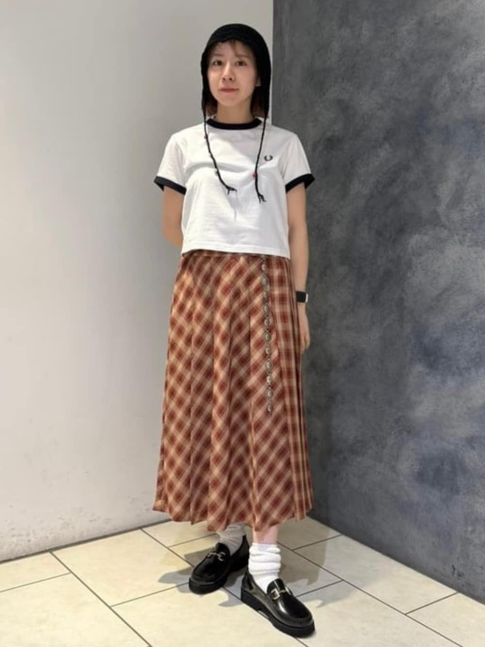 ブラウン系のスカート、ホワイト系のTシャツ/カットソー、ブラック系のニットキャップ/ビーニーを着用したレディースの夏コーディネートの1枚目の写真