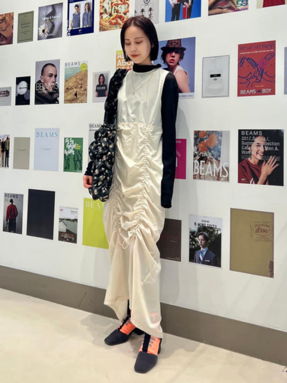 ベージュ系のワンピース、ブラック系のトートバッグ、ブラック系のTシャツ/カットソーを着用したレディースの冬コーディネートの1枚目の写真