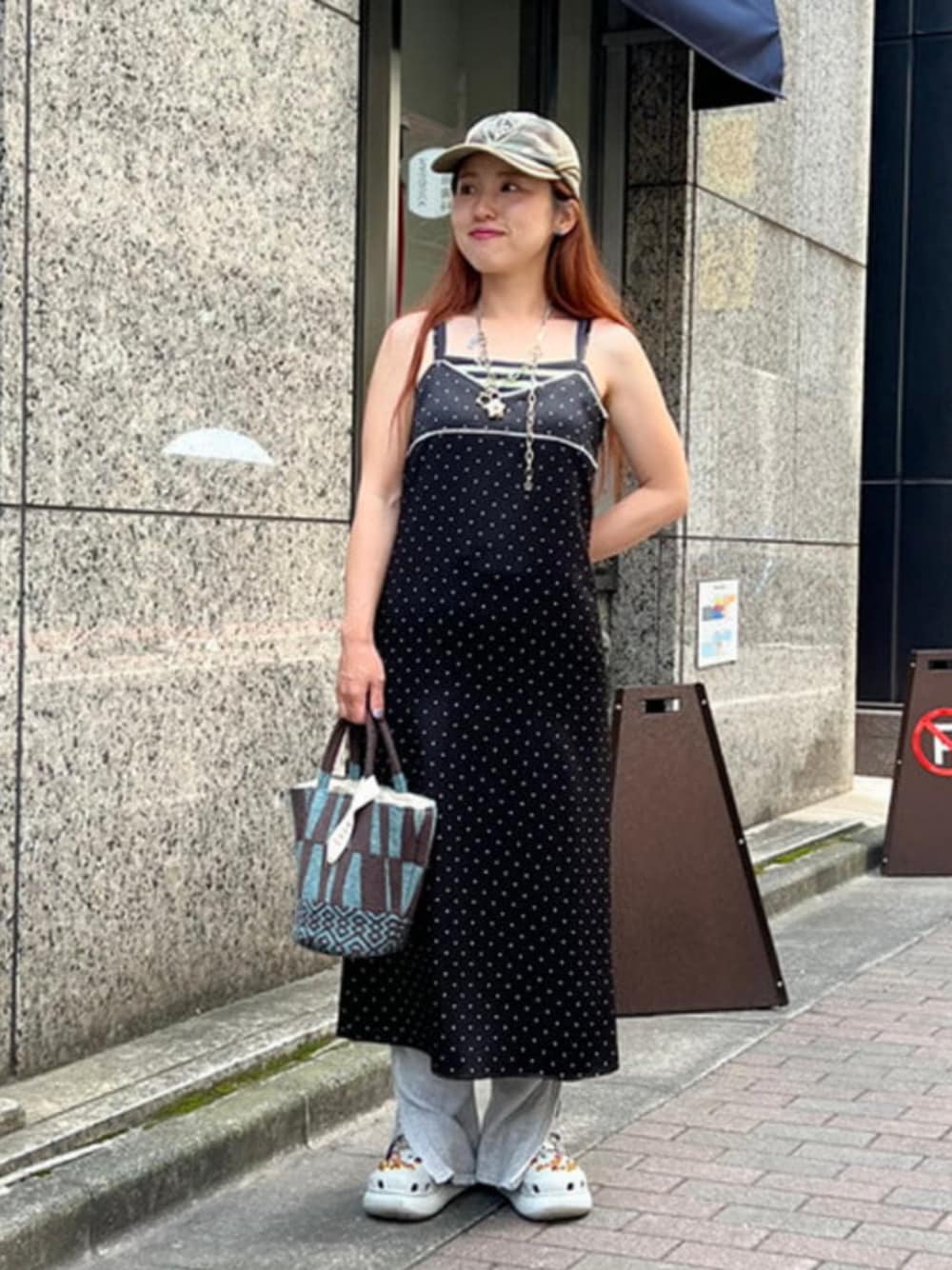 ブラック系のワンピース、ブルー系のトートバッグを着用したレディースの夏コーディネートの1枚目の写真