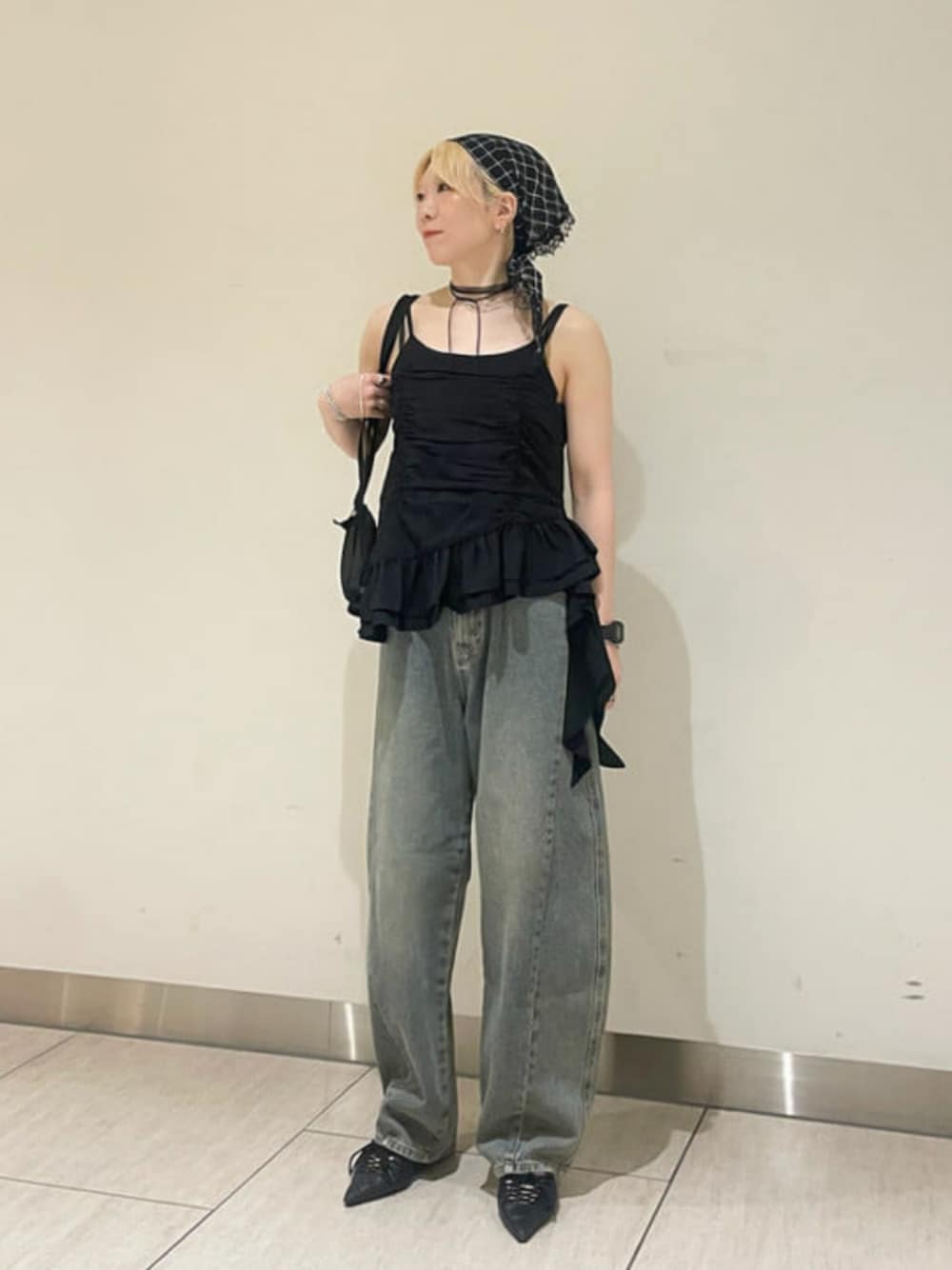 ブラック系のキャミソール、ブルー系のデニムパンツを着用したレディースの夏コーディネートの1枚目の写真
