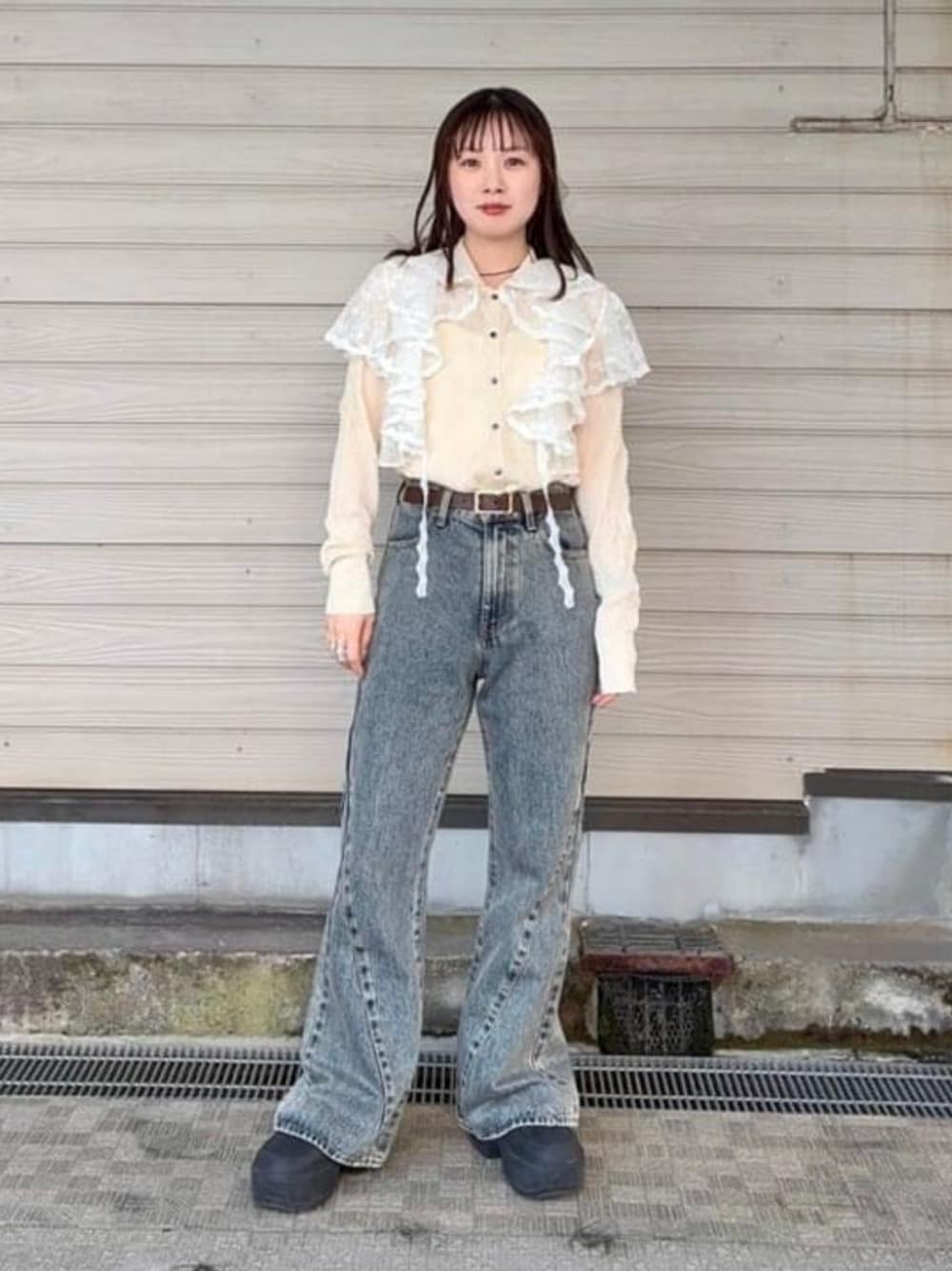 ブルー系のデニムパンツ、ホワイト系のカーディガン/ボレロ、ブラウン系のベルトを着用したレディースの春コーディネートの1枚目の写真