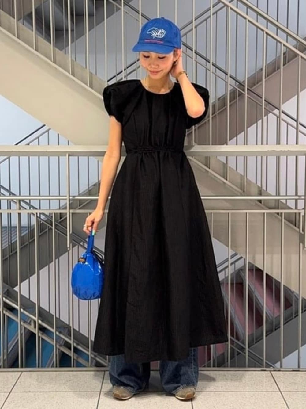 ブラック系のワンピースを着用したレディースの夏コーディネートの1枚目の写真