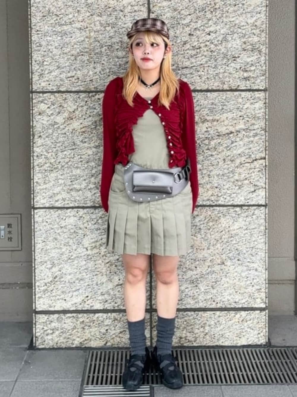 グリーン系のワンピース、レッド系のTシャツ/カットソー、ブラウン系のキャップを着用したレディースの秋コーディネートの1枚目の写真