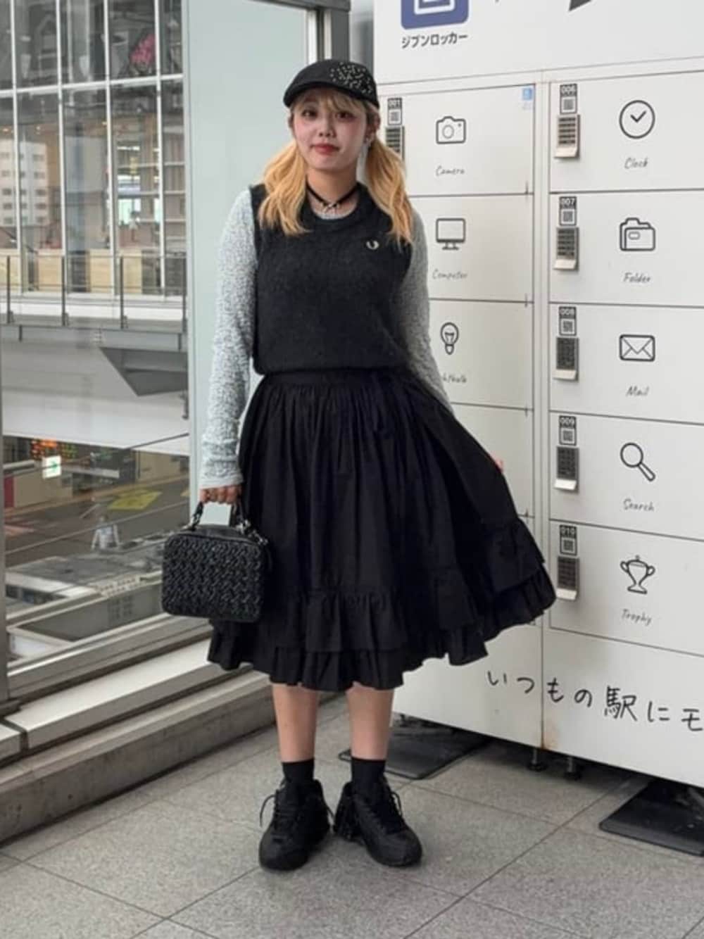 ブルー系のTシャツ/カットソー、ブラック系のハンドバッグ、グレー系のニット/セーターを着用したレディースの秋コーディネートの1枚目の写真