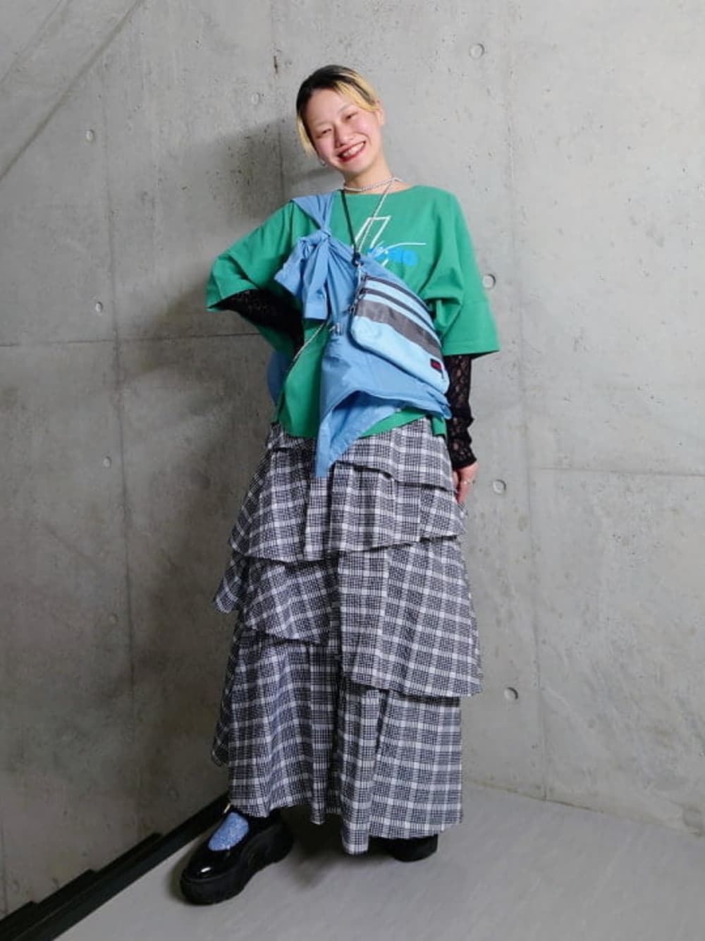 ブラック系のTシャツ/カットソー、ブラック系のスカート、ブルー系のナイロンジャケットを着用したレディースの春コーディネートの1枚目の写真