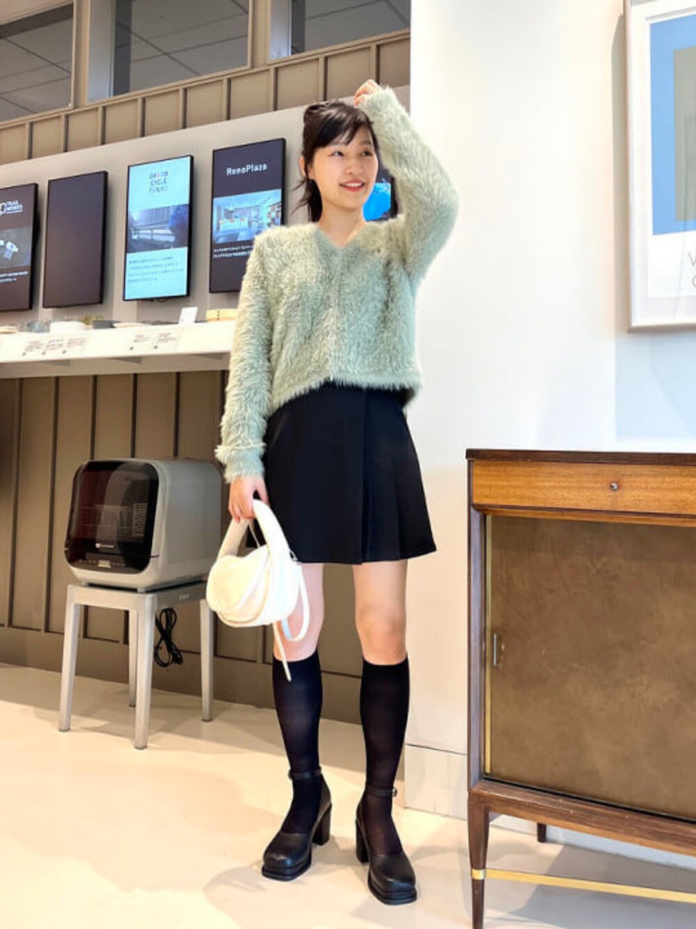 グリーン系のカーディガン/ボレロ、ブラック系のパンプスを着用したレディースの夏コーディネートの1枚目の写真