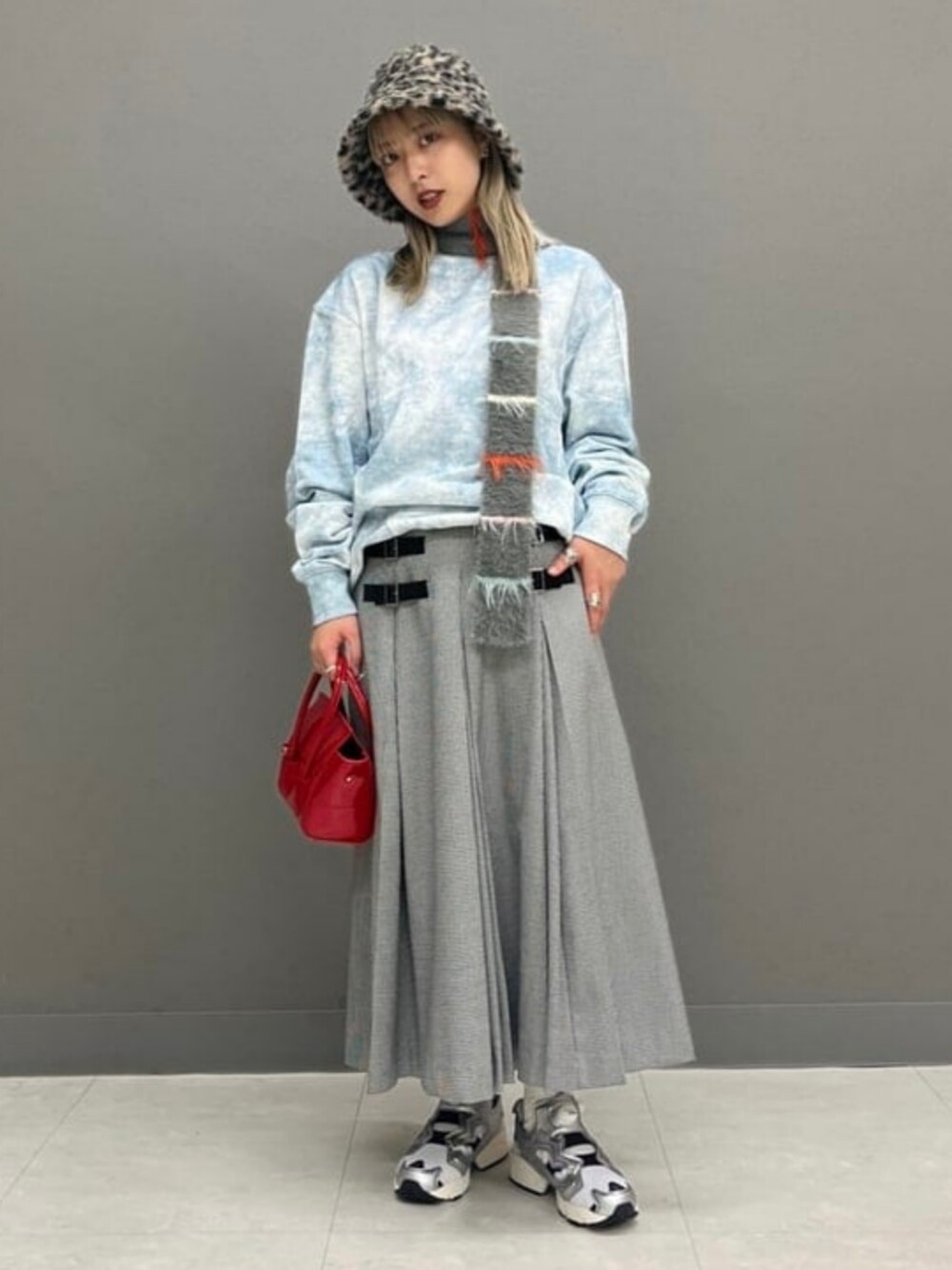 レッド系のトートバッグ、その他のスカート、ブルー系のスウェットを着用したレディースの秋コーディネートの1枚目の写真