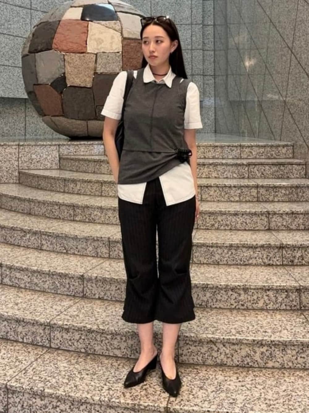 ブラウン系のトートバッグ、ブルー系のTシャツ/カットソー、ブラック系のパンプスを着用したレディースの夏コーディネートの1枚目の写真