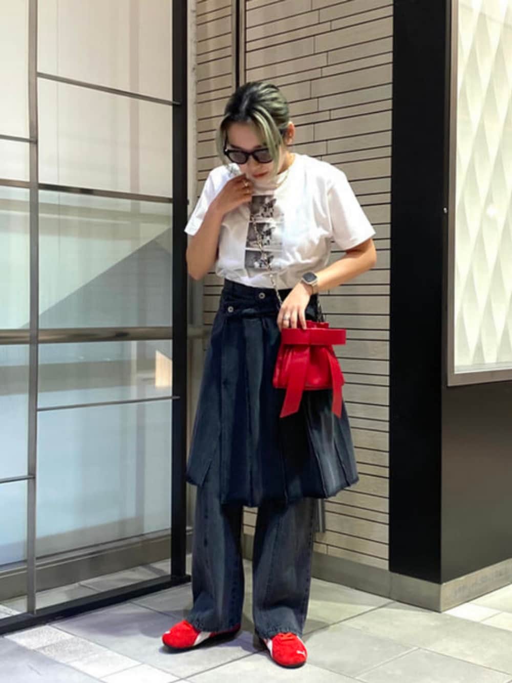 レッド系のショルダーバッグ、ホワイト系のTシャツ/カットソー、ブラック系のデニムパンツを着用したレディースの夏コーディネートの1枚目の写真