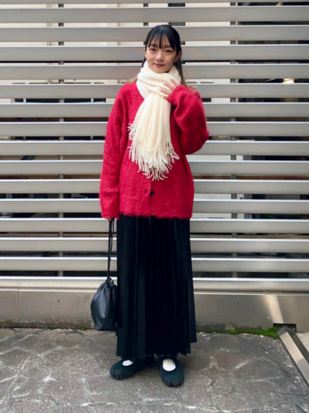 レッド系のカーディガン/ボレロ、ブラック系のスカート、ホワイト系のマフラーを着用したレディースの秋コーディネートの1枚目の写真
