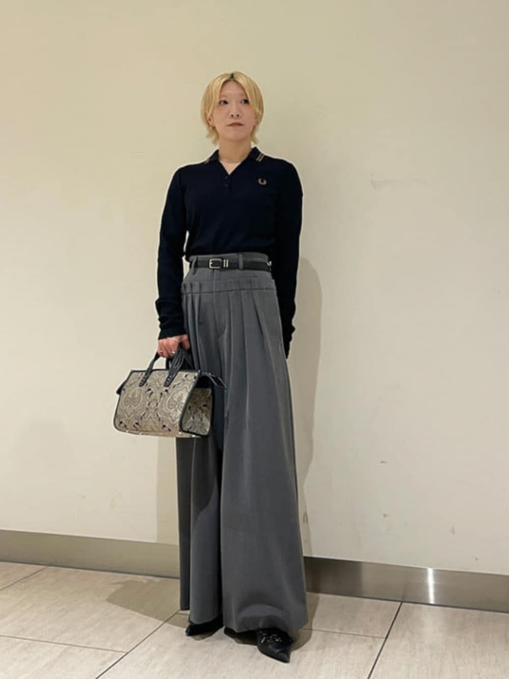 グレー系のその他パンツ、ブラック系のポロシャツ、ブラック系のトートバッグを着用したレディースの秋コーディネートの1枚目の写真
