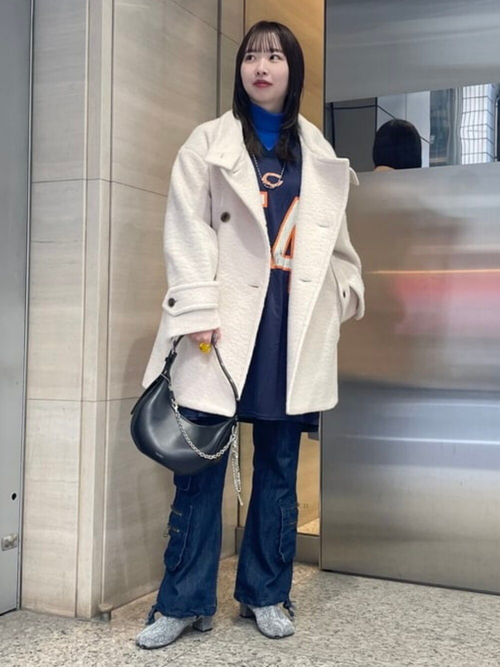 ブラック系のトートバッグ、ホワイト系のその他アウターを着用したレディースの冬コーディネートの1枚目の写真