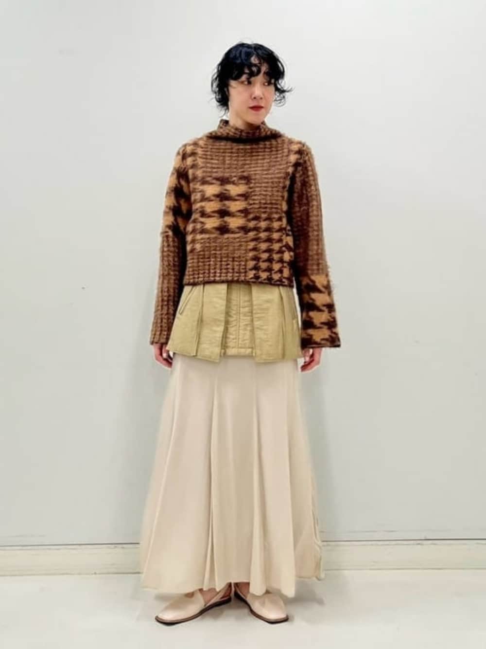 ベージュ系のスカートを着用したレディースの秋コーディネートの1枚目の写真