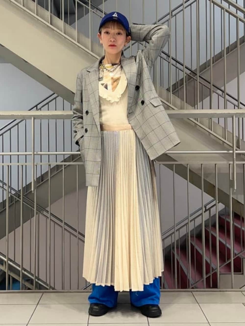 ホワイト系のスカート、ブラック系のテーラードジャケットを着用したレディースの冬コーディネートの1枚目の写真