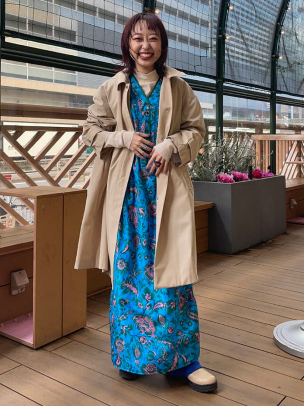 ベージュ系のステンカラーコートを着用したレディースの春コーディネートの1枚目の写真