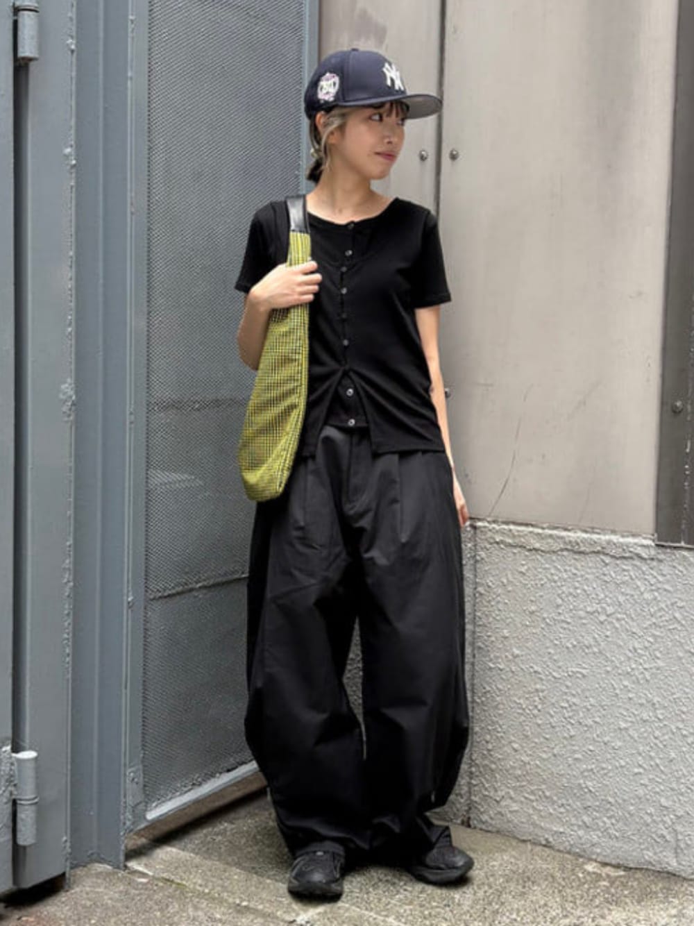 イエロー系のトートバッグ、ブラック系のTシャツ/カットソー、ブラック系のその他パンツを着用したレディースの夏コーディネートの1枚目の写真