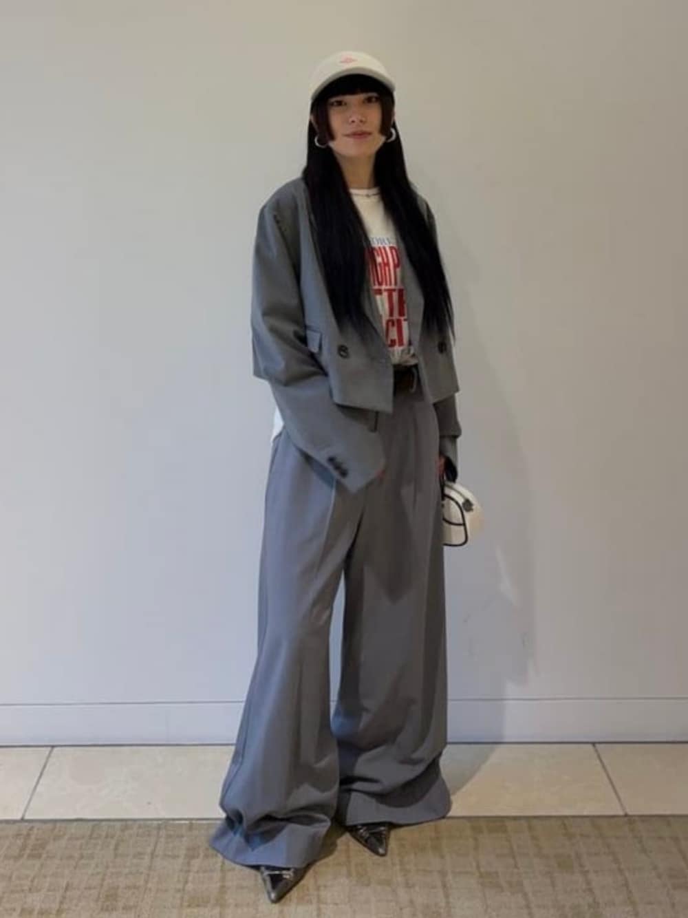 ホワイト系のTシャツ/カットソー、シルバー系のスラックス、グレー系のテーラードジャケットを着用したレディースの春コーディネートの1枚目の写真