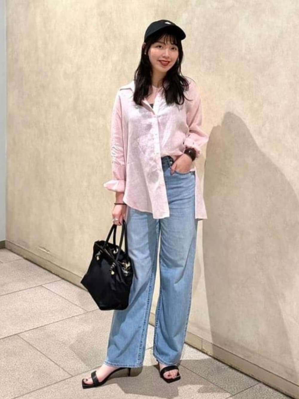 ブルー系のシャツ/ブラウス、ブルー系のデニムパンツ、ブラック系のキャップを着用したレディースの春コーディネートの1枚目の写真