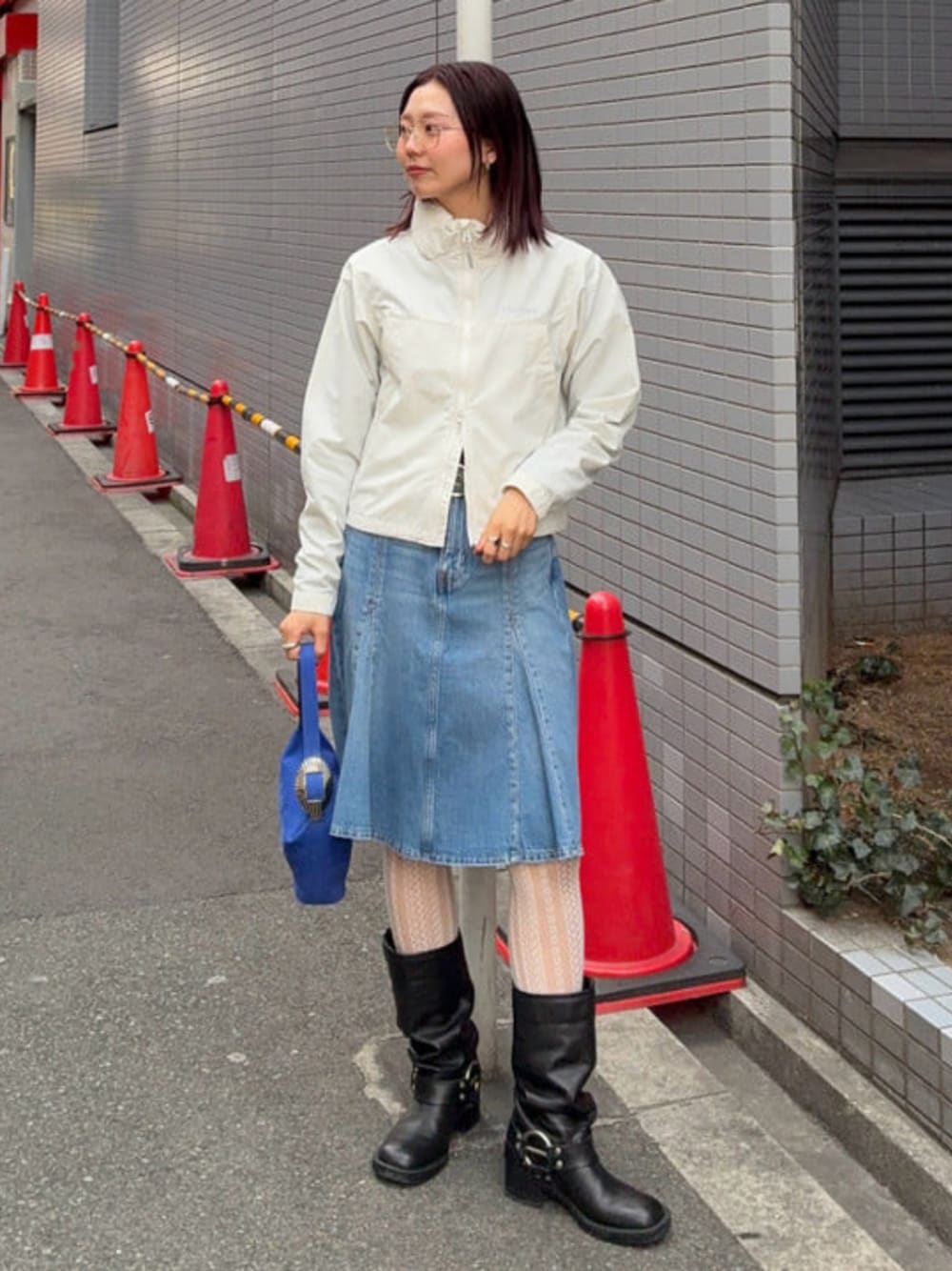 ホワイト系のナイロンジャケット、ブルー系のスカートを着用したレディースの春コーディネートの1枚目の写真