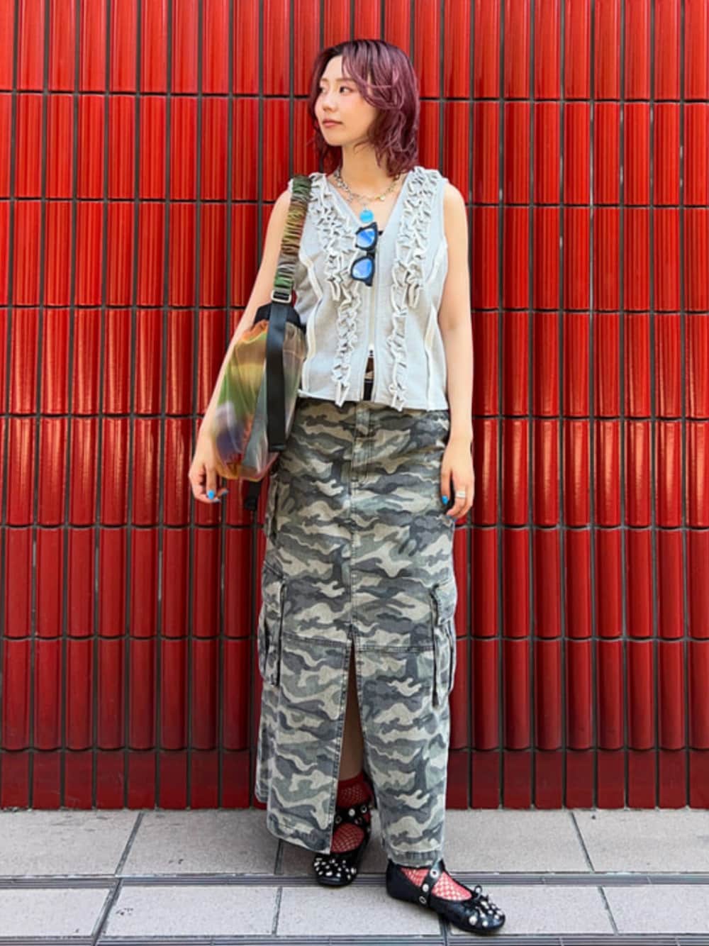 グリーン系のスカート、グレー系のベスト、その他のショルダーバッグを着用したレディースの夏コーディネートの1枚目の写真