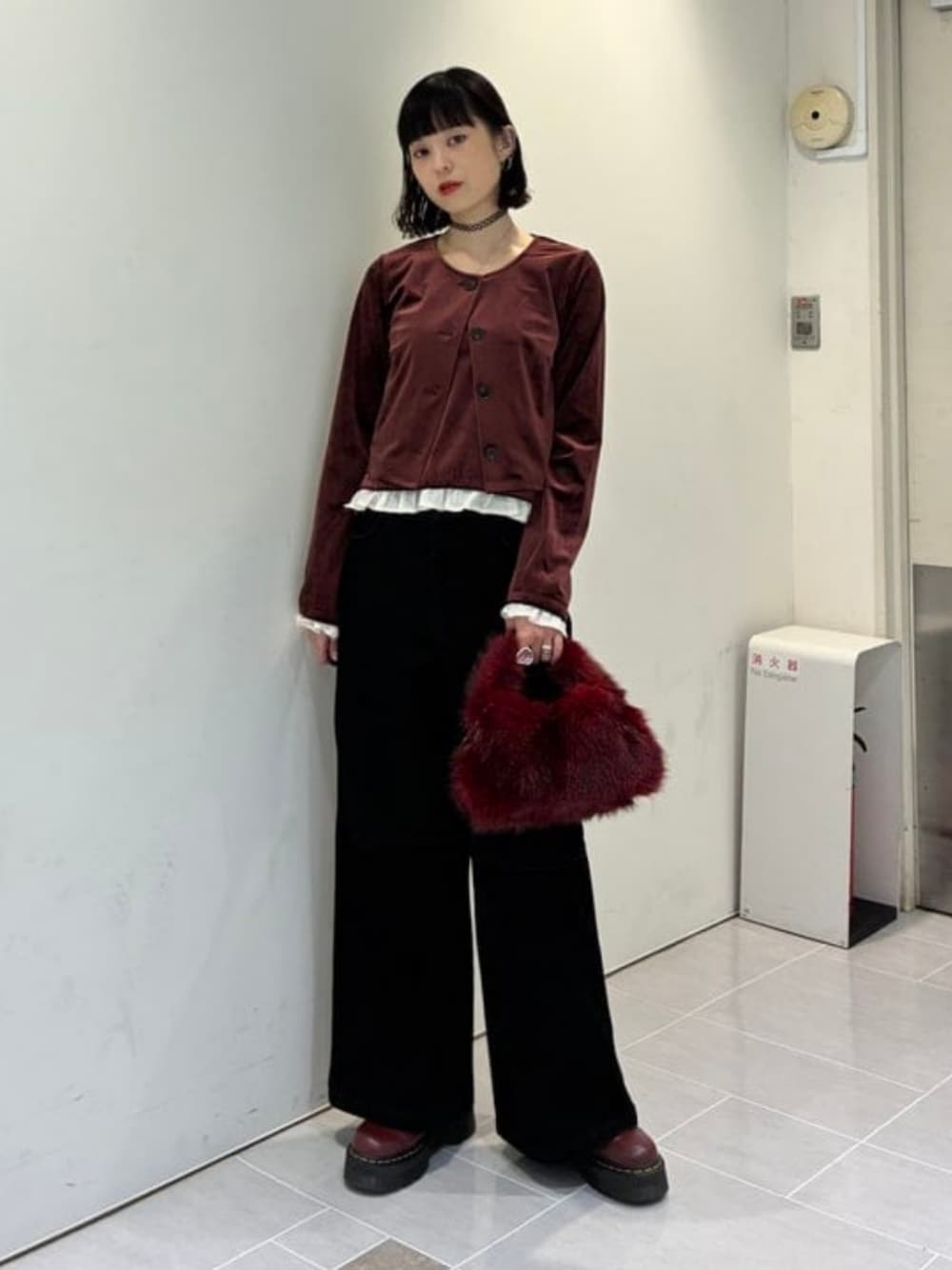 ブラック系のデニムパンツ、レッド系のトートバッグ、ブラウン系のアンサンブルを着用したレディースの秋コーディネートの1枚目の写真