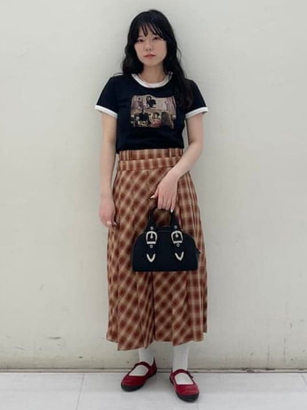 ブラック系のボストンバッグ、ブラック系のTシャツ/カットソー、ブラウン系のスカートを着用したレディースの春コーディネートの1枚目の写真