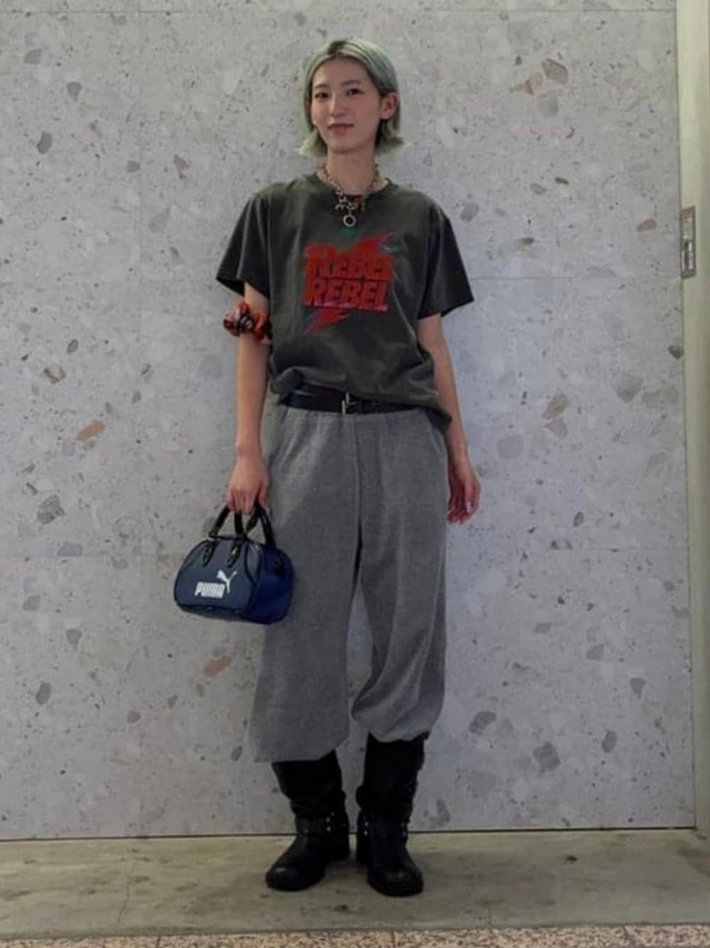 ブルー系のハンドバッグ、ブラック系のTシャツ/カットソー、ブラック系のベルトを着用したレディースの夏コーディネートの1枚目の写真